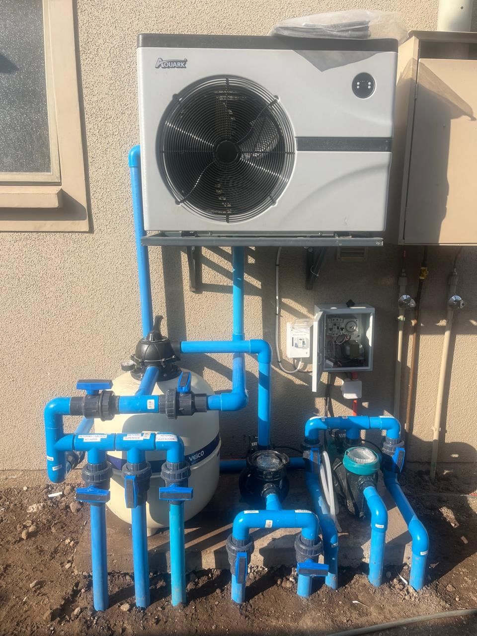 Bomba de calor Aquark instalada sobre la sala de equipos de una piscina