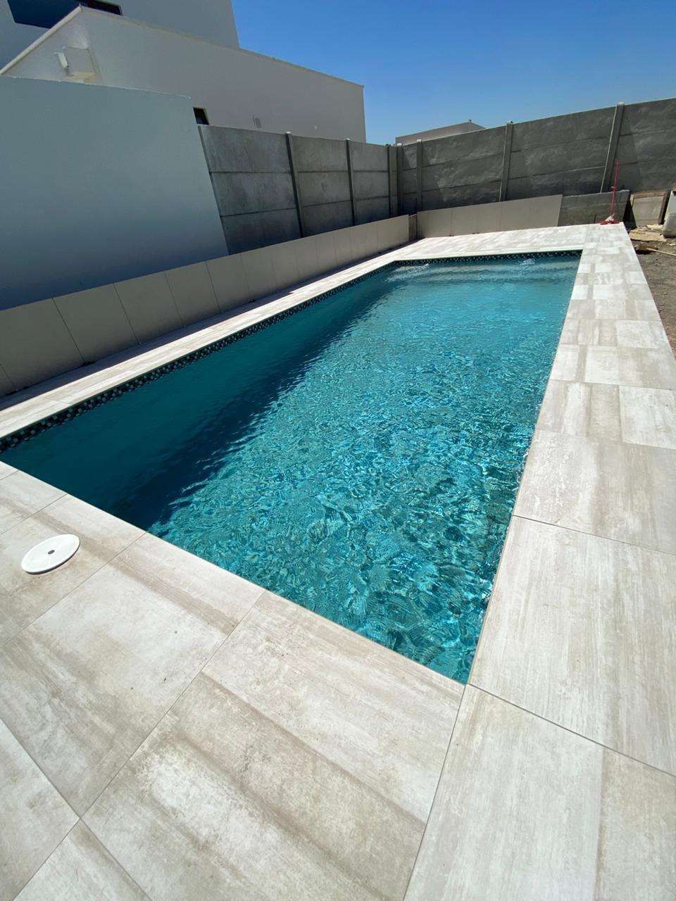 Piscina de fibra Roble instalada, con cascada y agua cristalina